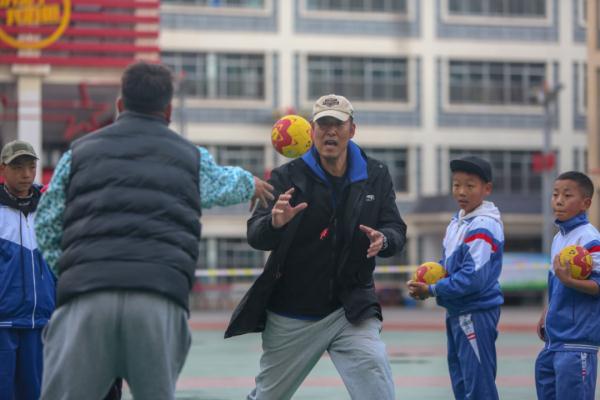 在高原上教孩子們打手球，“慢慢兒來，甭著急！”