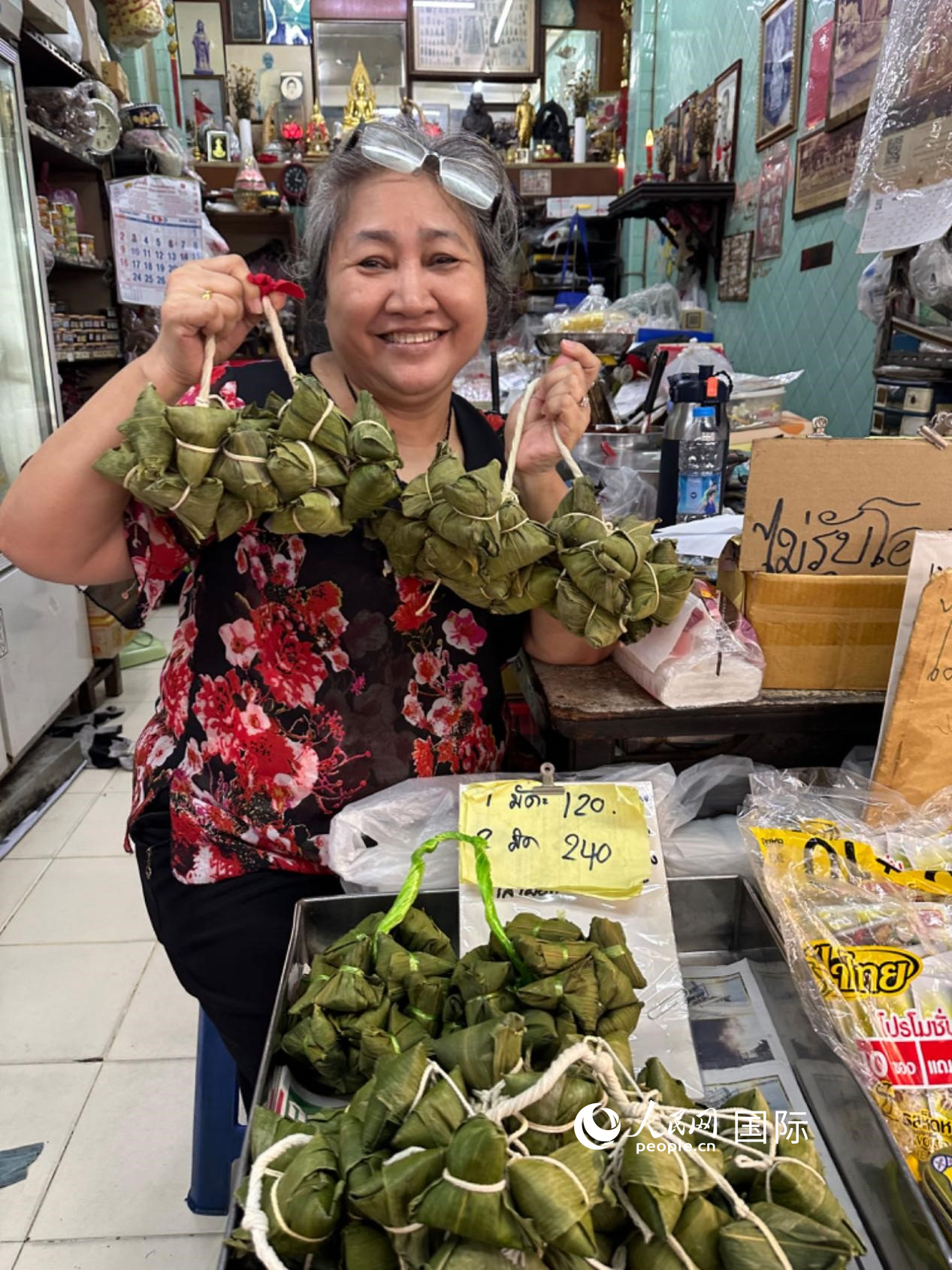 商家向顧客介紹“吉掌”（粽子的一種，一串一串，個(gè)頭較小）。人民網(wǎng)記者 簡(jiǎn)承淵攝