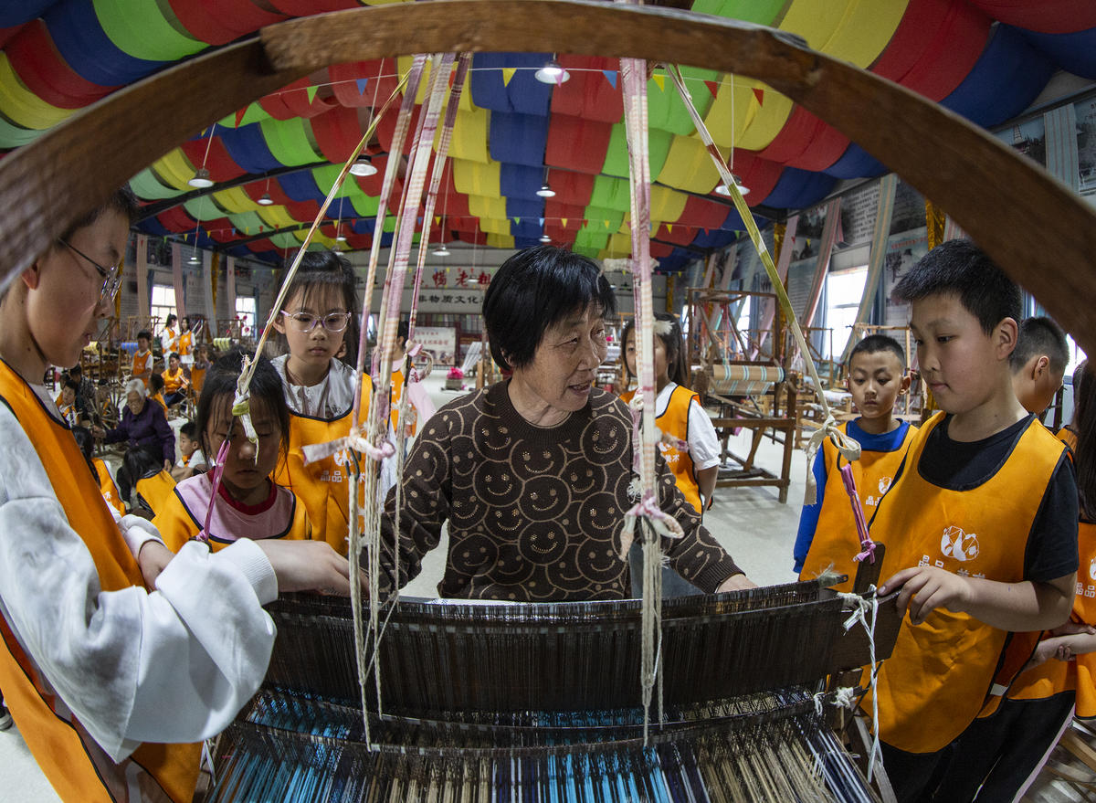5月1日，在山西省永濟市開張鎮(zhèn)東開張村的惠暢土布文化園，土布制作技師教游客織布技藝。 來源：人民圖片網(wǎng)