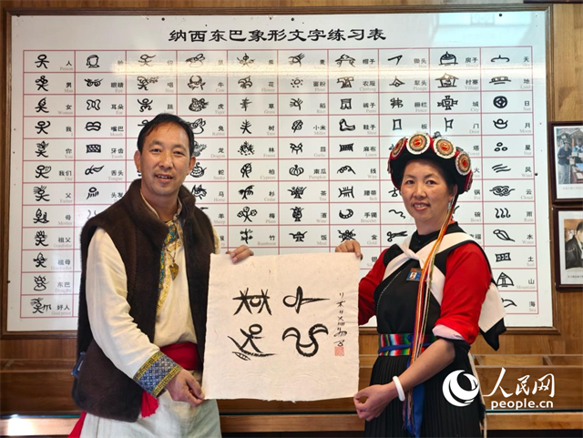 人民網(wǎng)“行進中國”云南調(diào)研采訪團走進麗江，和閏元現(xiàn)場用東巴文寫下“行進中國”。人民網(wǎng)記者 符皓攝
