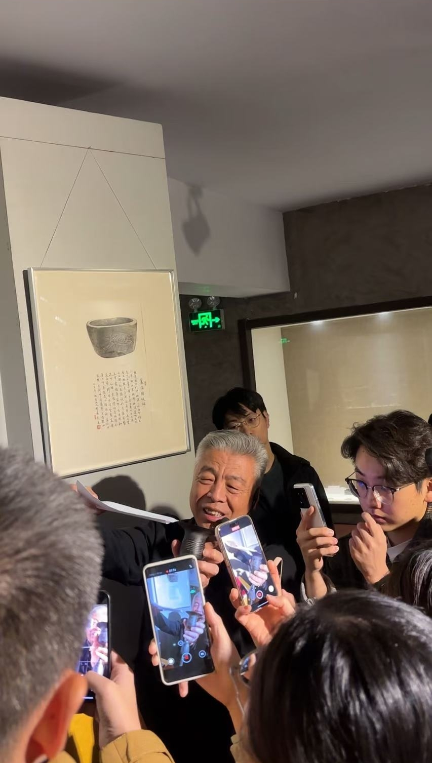 黑陶邢文化博物館館長邢葆東展示兩張相疊的A4紙，向記者解釋此為杯口的厚度。