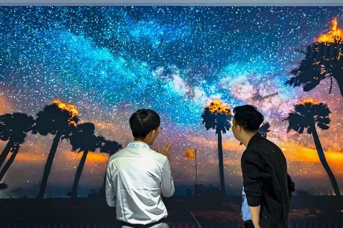 長(zhǎng)春光博會(huì)希達(dá)電子展區(qū)，一位工作人員正在給一位觀眾講解。（長(zhǎng)春新區(qū)供圖）