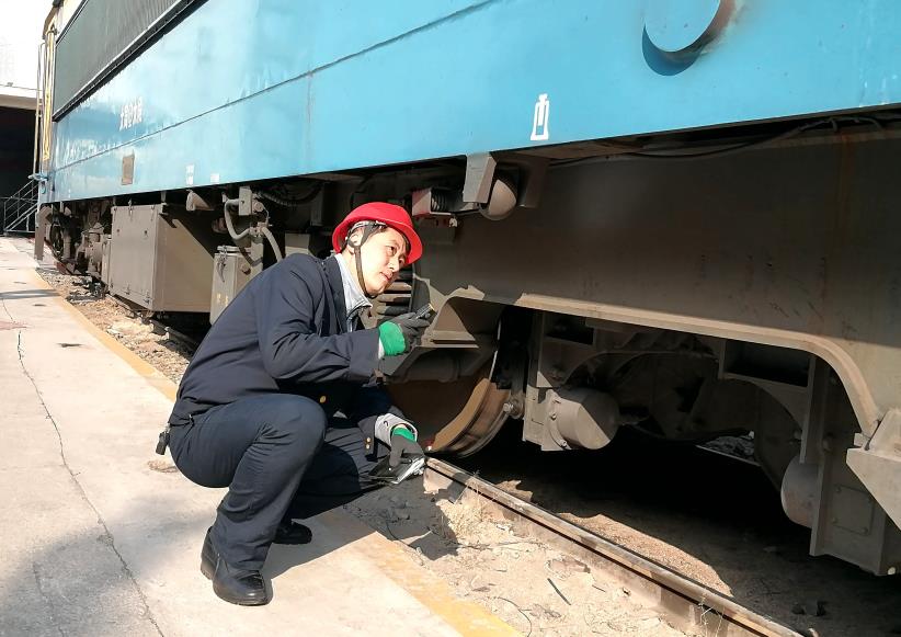 韓文盛全神貫注檢查機(jī)車走行部。