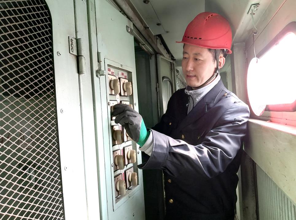 韓文盛認(rèn)真檢查低壓柜。