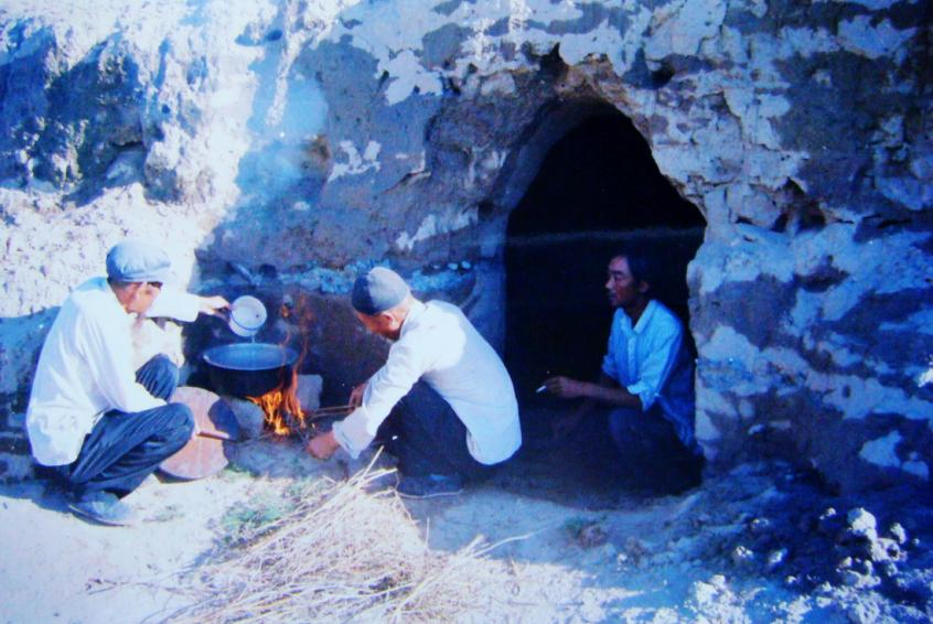 1983年，“六老漢”一代治沙人在“地窩子”生活做飯。新華社發(fā)（八步沙林場供圖）