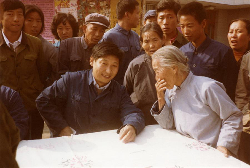 1983年，時(shí)任河北正定縣委書記的習(xí)近平（前排居中），臨時(shí)在大街上擺桌子聽取老百姓意見。
