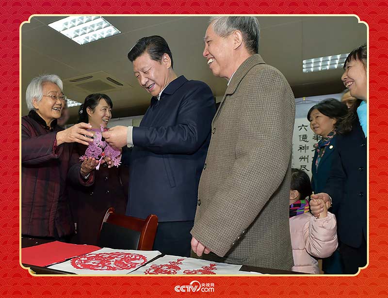 2015年2月15日，習近平在西安市雁塔區(qū)電子城街道二〇五所社區(qū)服務中心欣賞社區(qū)居民的剪紙作品。