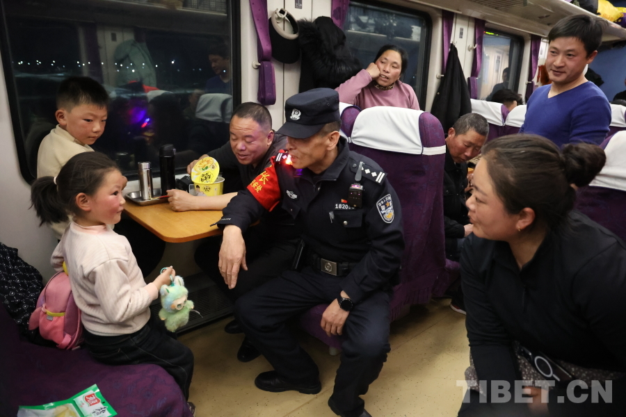 乘警長左紅彬在巡視車廂間隙，向攜帶兒童的旅客專門叮囑安全注意事項。.JPG