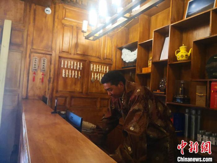 圖為桑杰才讓用電腦處理財(cái)務(wù)?！∈缝o靜 攝