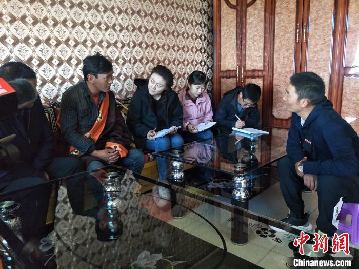 圖為調(diào)查組工作人員正在入戶調(diào)查?！∑钤鲚?攝