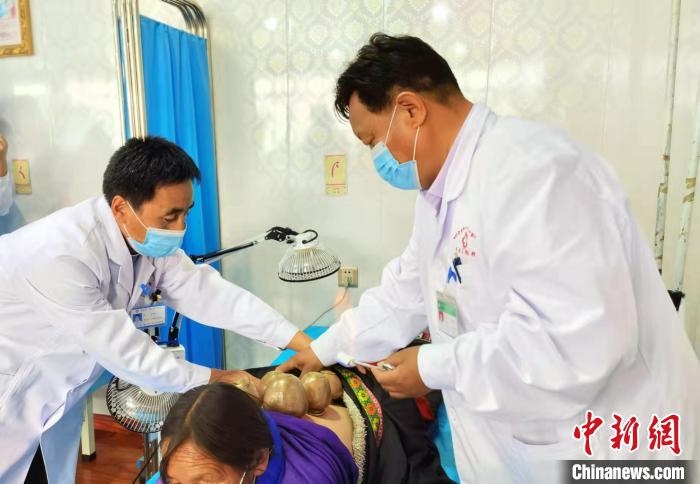 圖為看照加手把手帶徒弟加老(左一)進行拔罐療法?！堟?攝