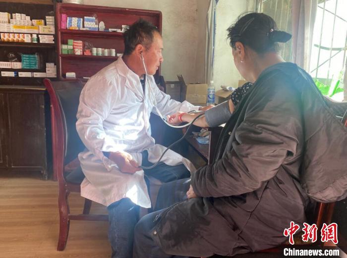 索木滾(左)為村民看病?！∪捞量h委宣傳部供圖