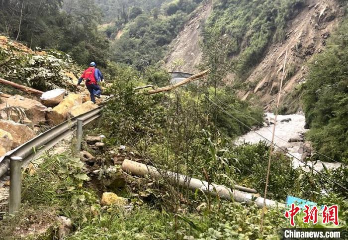 電力搶險人員快速通過危險路段，旁邊是受損的電力線路 四川電力供圖
