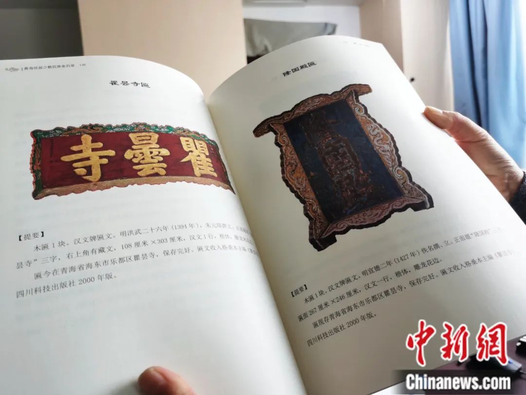 古籍保護人員展示介紹明代朱元璋撰寫的青海瞿曇寺匾(左)的出版書籍。張?zhí)砀?攝