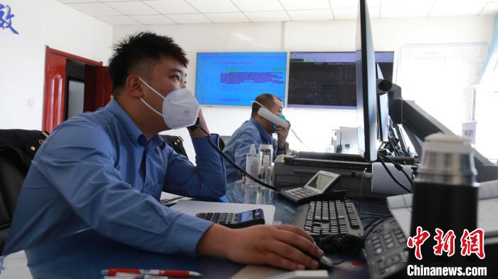 圖為貨運調(diào)度人員與外勤工作人員聯(lián)系掌握車輛裝載情況?！±钌?攝