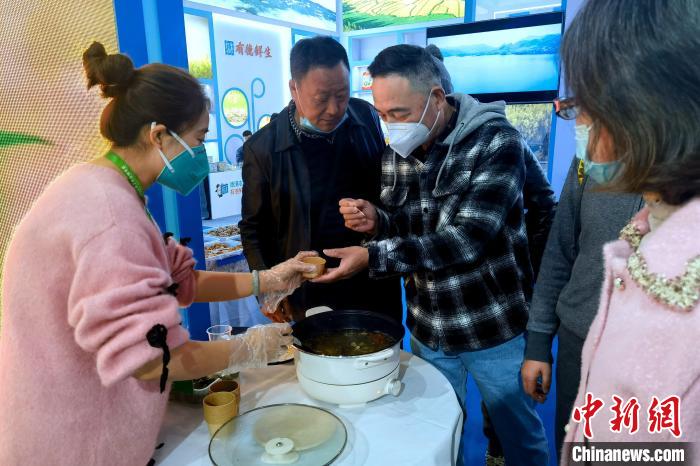 圖為杭州市民品嘗茶卡羊肉。　李雋 攝