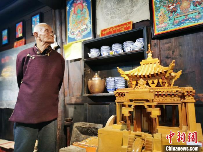 圖為古堡內(nèi)的藝人桑杰展示自己的雕刻作品?！?zhí)砀?攝