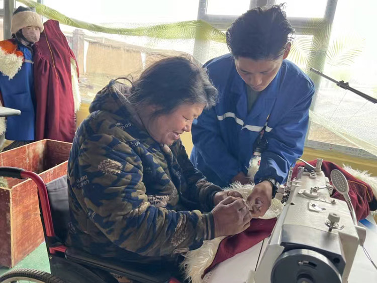 扎西奪爾登幫助殘疾員工裁剪。阿壩州文明辦供圖
