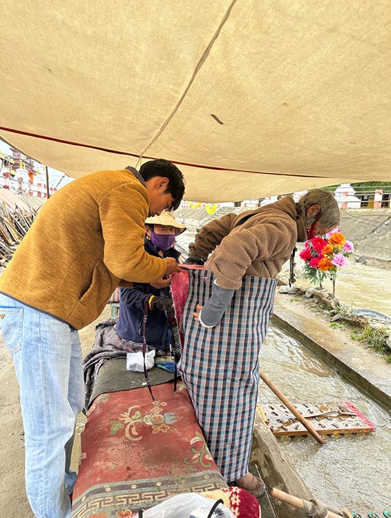 扎西奪爾登為路邊老人送去保暖圍腰。阿壩州文明辦供圖