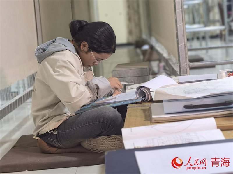 正在學(xué)習(xí)畫底稿的尕讓旺姆。人民網(wǎng) 陳明菊攝