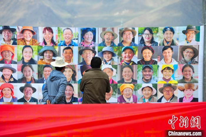 圖為當(dāng)?shù)孛癖娫谟^看展板上的笑臉?！垈?攝