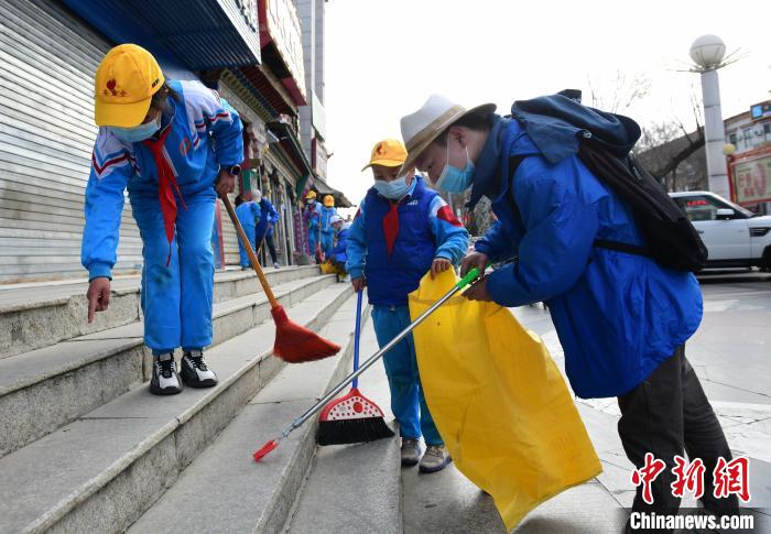 圖為拉薩市小學(xué)生打掃街道?！∝暩聛硭?攝