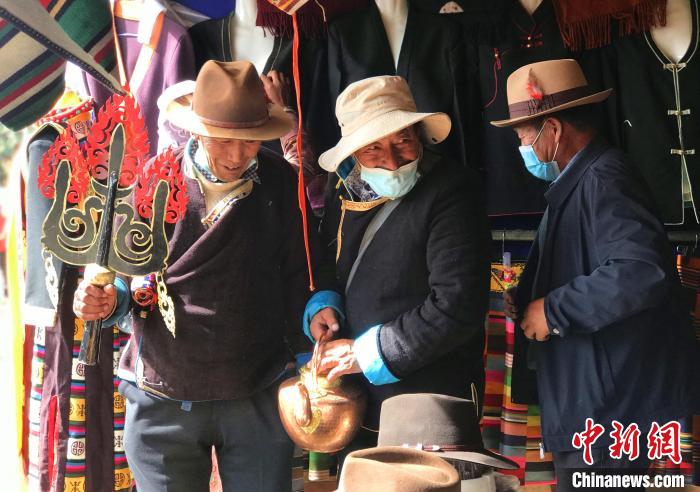 圖為三位藏族老人在集市上聊天交談?！∪轿木?攝