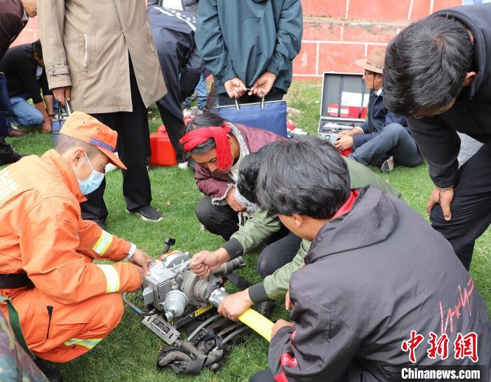 圖為森林消防員為護(hù)林員講解滅火裝備的使用方法。　昌都市森林消防支隊(duì) 供圖