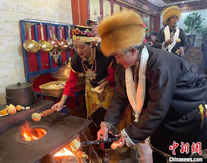 圖為人們在火上烤節(jié)日美食“結達”?！∪轿木?攝