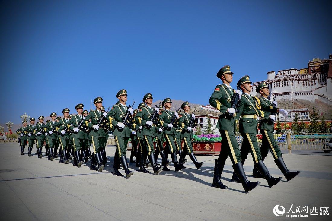 國旗護衛(wèi)隊隊員緊握鋼槍，踏著威武雄壯的步伐，走向國旗臺。人民網 次仁羅布攝