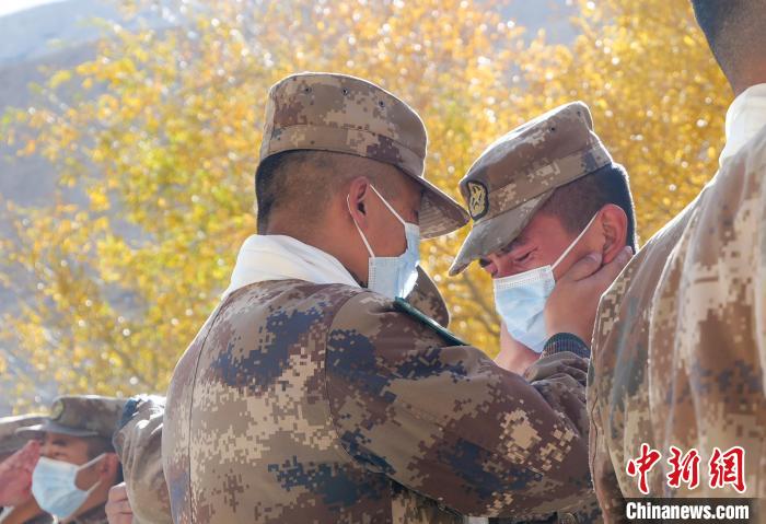 圖為什布奇邊防連退伍老兵與戰(zhàn)友相擁而泣，依依惜別?！⌒觳?攝