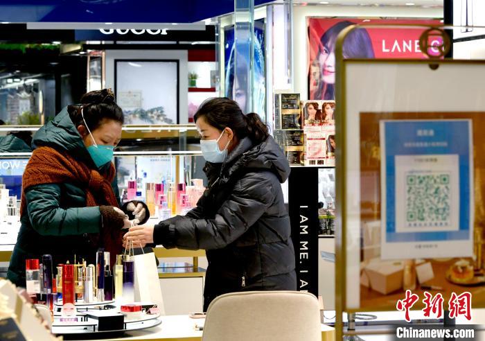 12月7日，拉薩，市民掃碼進(jìn)入拉薩百貨大樓選購護(hù)膚品。　李林 攝