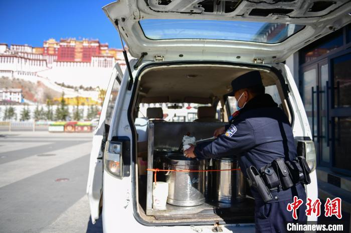 圖為1月23日，布達(dá)拉宮廣場(chǎng)派出所民警正在打午飯?！∝暩聛?lái)松 攝
