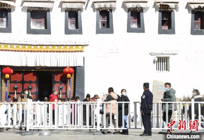 圖為1月23日，布達(dá)拉宮廣場(chǎng)派出所民警正在引導(dǎo)游客?！∝暩聛?lái)松 攝