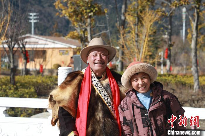 圖為林芝市巴宜區(qū)布久鄉(xiāng)仲果村村民桑杰與孫子一起參加藏歷新年活動?！埩?攝