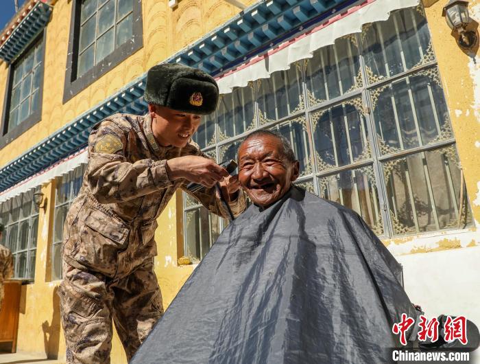 圖為阿里軍分區(qū)某邊防團官兵為駐地群眾理發(fā)迎藏歷新年?！〉┰鰝愔?攝