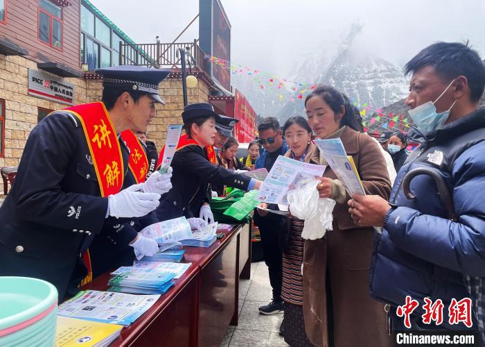 圖為山南玉麥邊境派出所民警為轄區(qū)群眾發(fā)放法律知識(shí)宣傳單?！＄婗?　攝