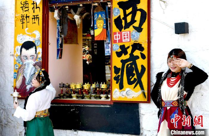 4月17日，游客身著藏式元素服裝在拉薩八廓街拍照留念?！±盍?攝