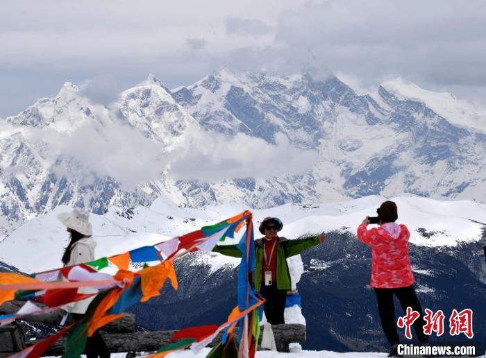 圖為5月14日，西藏林芝色季拉山觀景臺(tái)，游客與南迦巴瓦峰合影?！±盍?攝