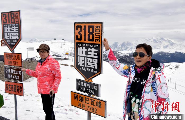 圖為5月14日，西藏林芝色季拉山觀景臺(tái)，游客與南迦巴瓦峰合影?！±盍?攝
