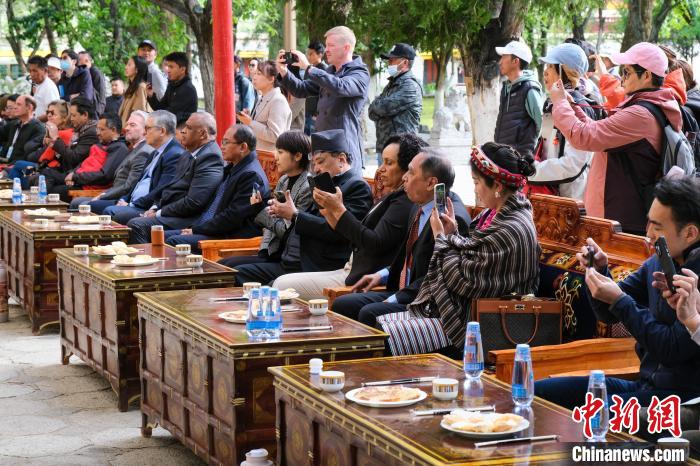 5月19日，中外嘉賓在羅布林卡和游客一起觀看藏戲。　江飛波 攝