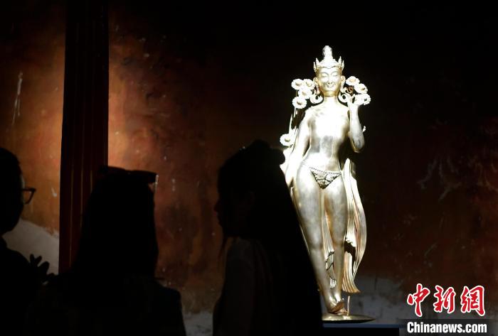圖為觀眾正在欣賞展覽中的雕塑作品《八萬四千年》?！±盍?攝