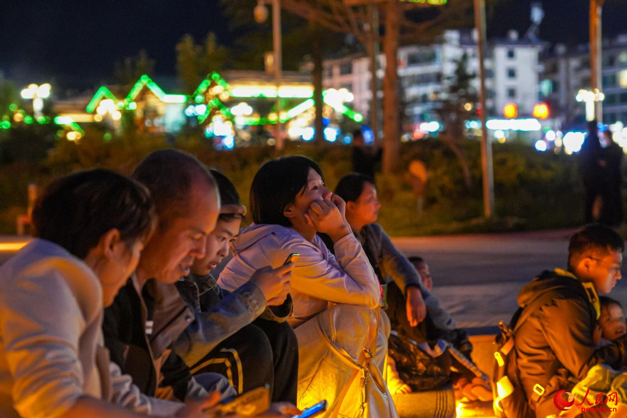 市民坐在西藏林芝市民族團(tuán)結(jié)廣場臺(tái)階上欣賞音樂噴泉。人民網(wǎng)記者 趙晨攝