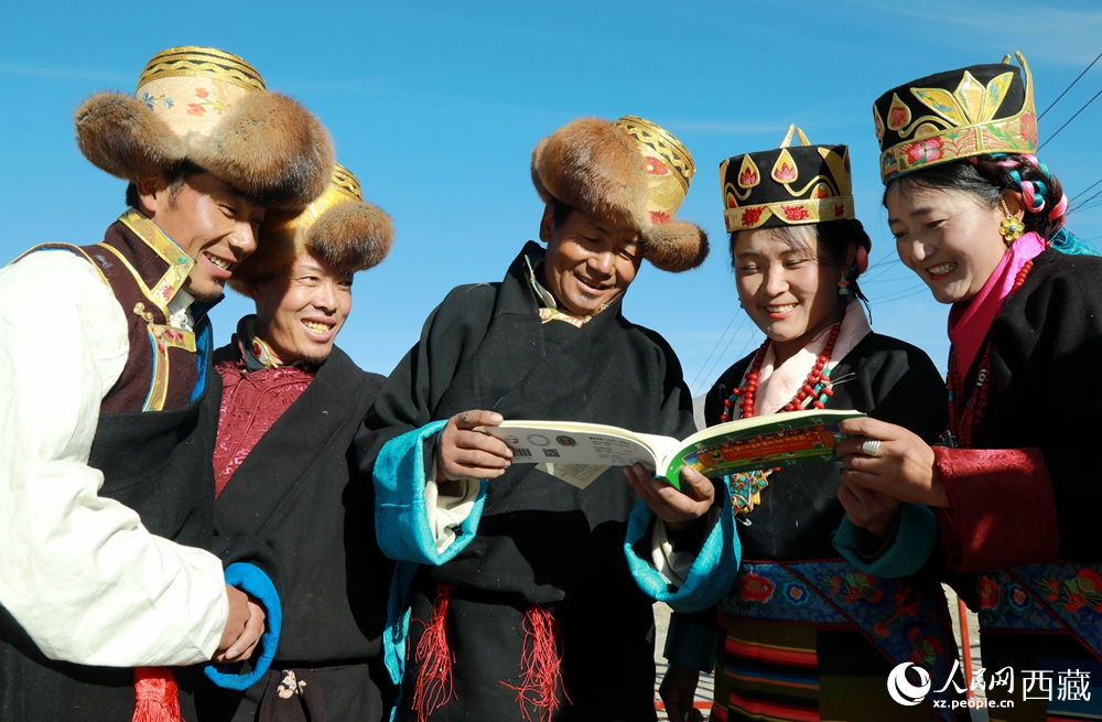 鄉(xiāng)親們身著民族盛裝，圍站在一起認真翻看日歷，共話農(nóng)事安排與時節(jié)規(guī)律，笑容洋溢傳遞豐收期盼。人民網(wǎng)記者 吳雨仁攝