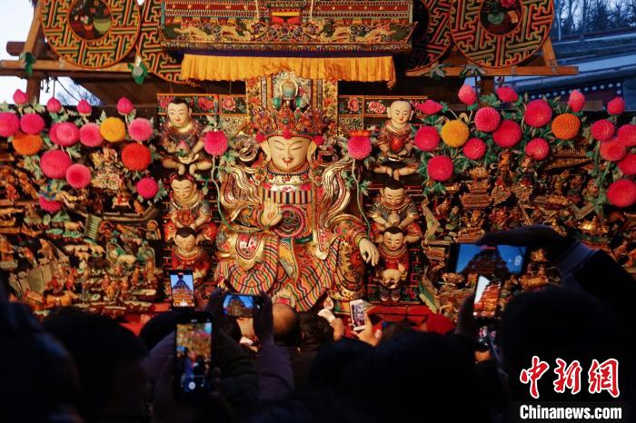 圖為游客觀賞塔爾寺酥油花展，并用手機記錄?！●R銘言 攝