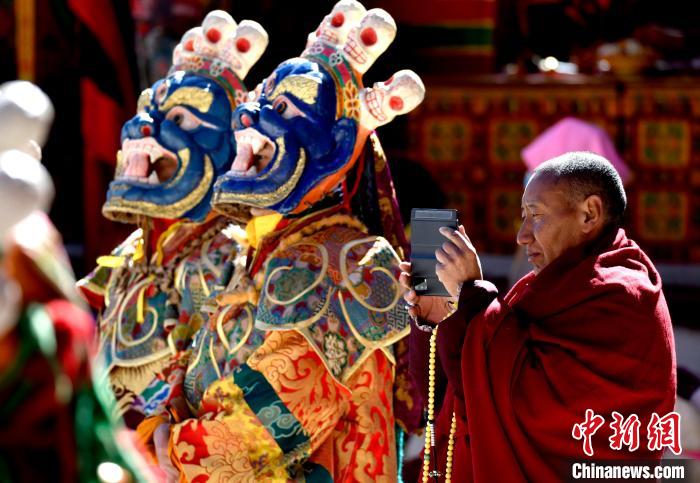 2月19日，正在拍攝跳神活動的僧人?！±盍?攝