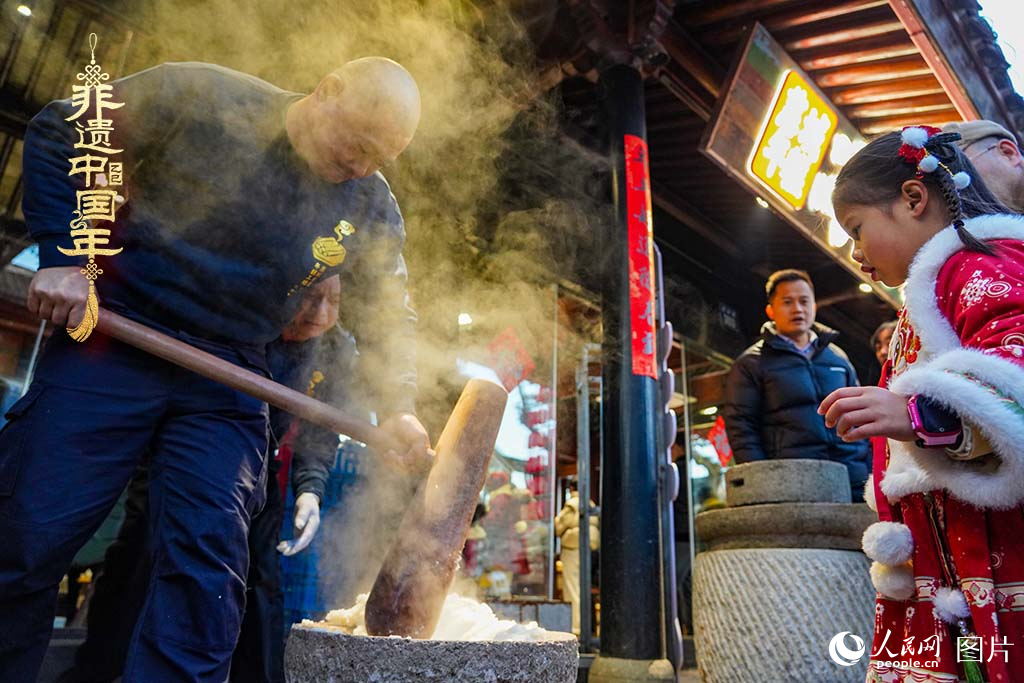 2025年1月29日，浙江省寧波市江北區(qū)慈城古縣城，市民和游客觀看搗年糕。人民網(wǎng) 章勇濤攝