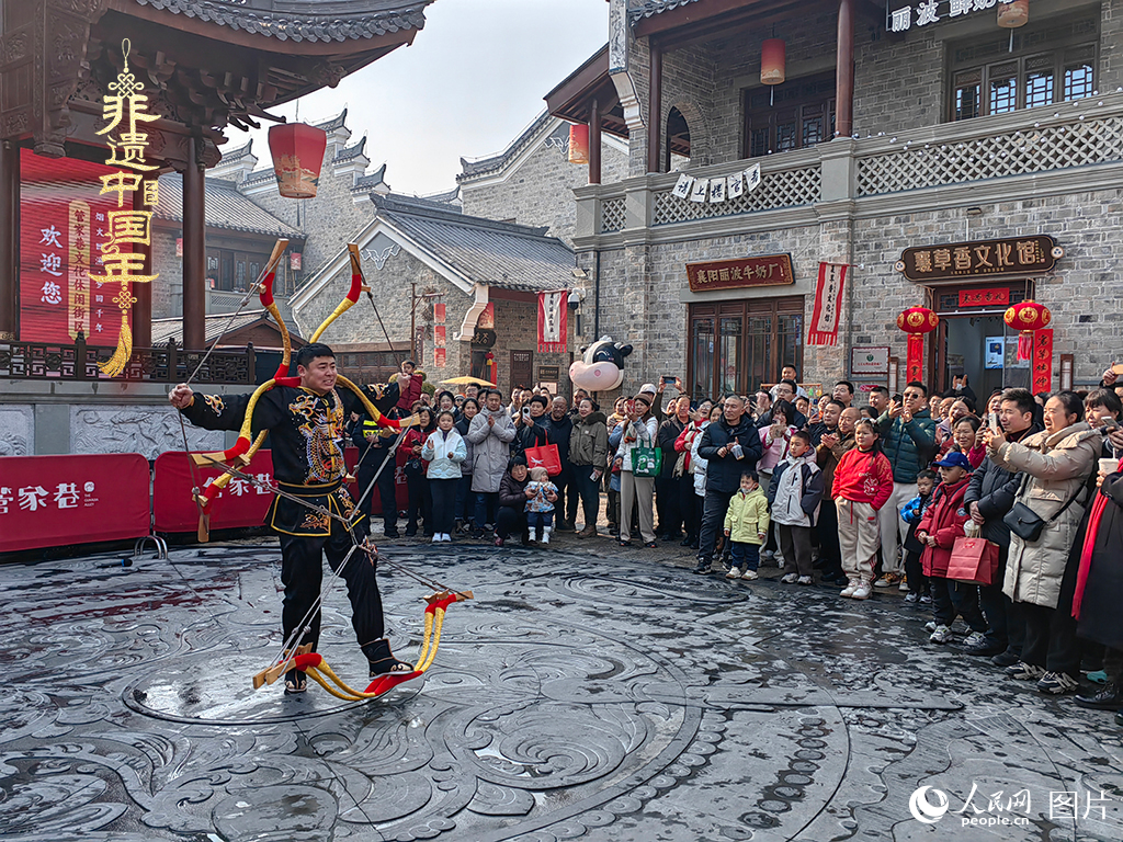 2025年1月29日，湖北襄陽市管家巷，老北京天橋大刀張舉大刀拉硬弓第五代傳承人現(xiàn)場(chǎng)表演，一次拉開6張弓，引來游客喝彩。人民網(wǎng)記者 郭婷婷攝