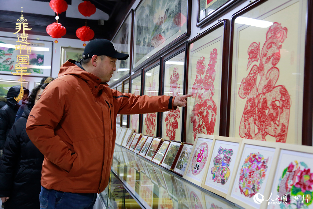 2025年1月23日，游客在天津楊柳青古鎮(zhèn)欣賞傳統(tǒng)剪紙作品，感受指尖上的古老藝術(shù)。人民網(wǎng)記者 崔新耀攝