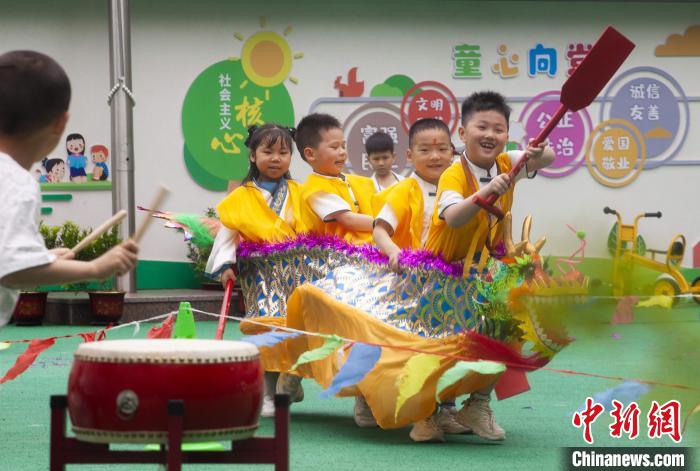 圖為龍舟賽游戲上，小伙伴們打鼓加油?！《^生 攝